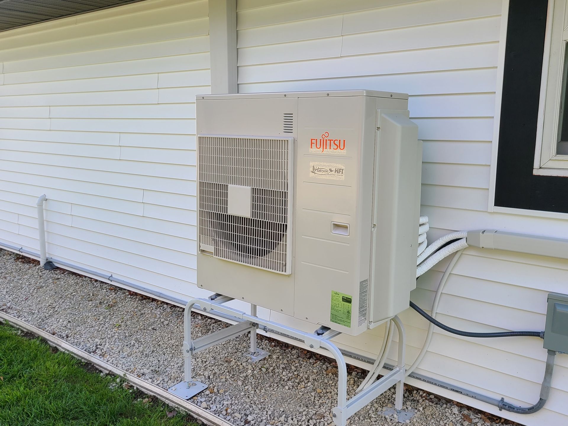 An air conditioner is sitting on the side of a house.