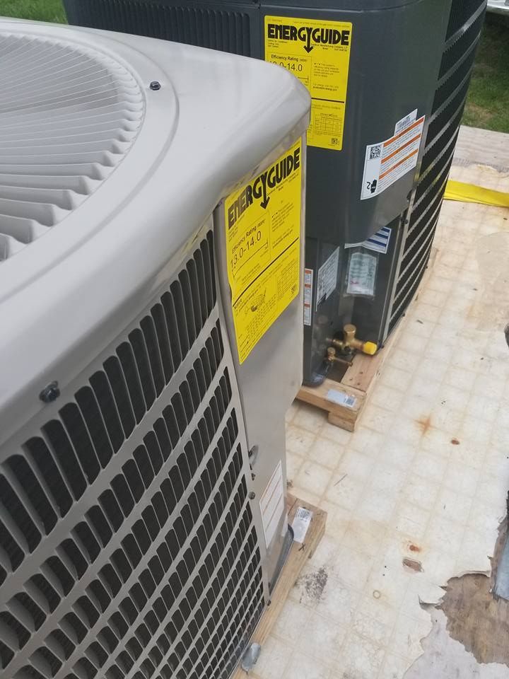 A couple of air conditioners are sitting next to each other on a tiled floor.
