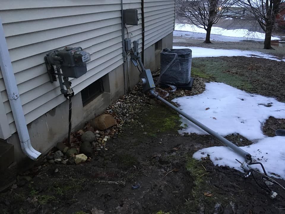 A house with a drain pipe coming out of the side of it.