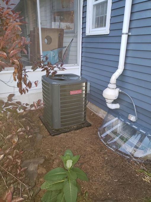 A large boiler is sitting in a basement next to pipes.