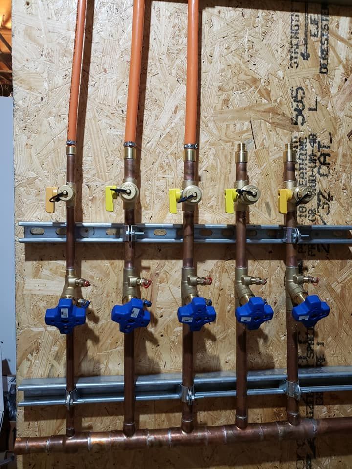 A row of copper pipes with blue valves attached to them