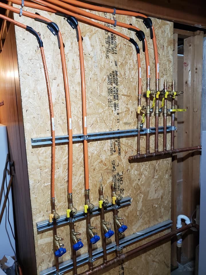 A wall with a bunch of pipes and valves on it
