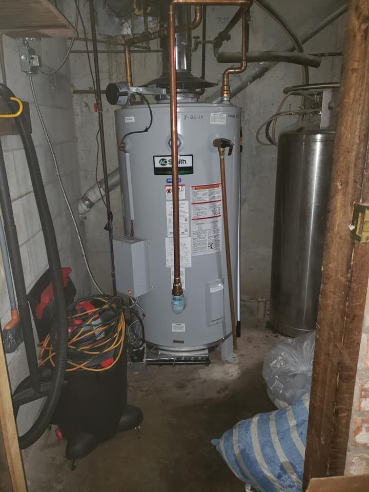 A room with a water heater and a vacuum cleaner in it.