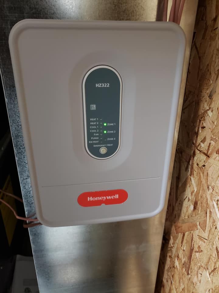 A white box with a honeywell logo on it is hanging on a wall.