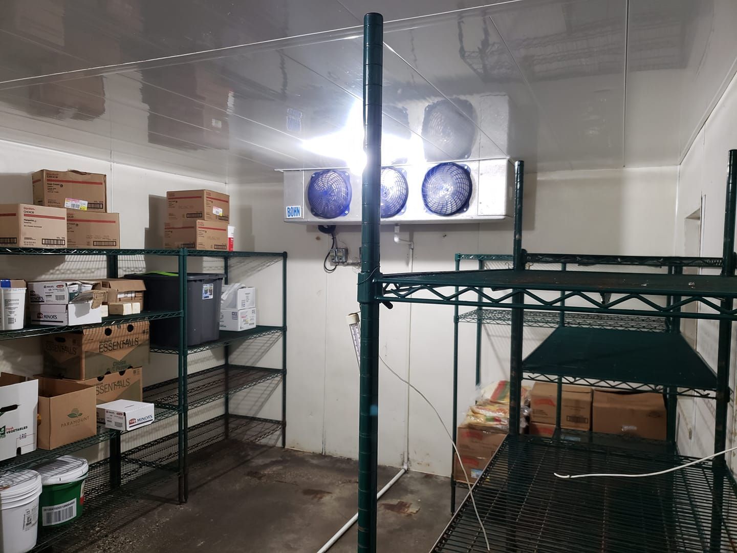 A room filled with shelves and boxes and a refrigerator.