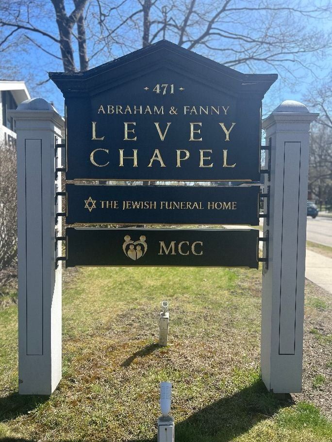 The front door of a house with a porch and plants in front of it.