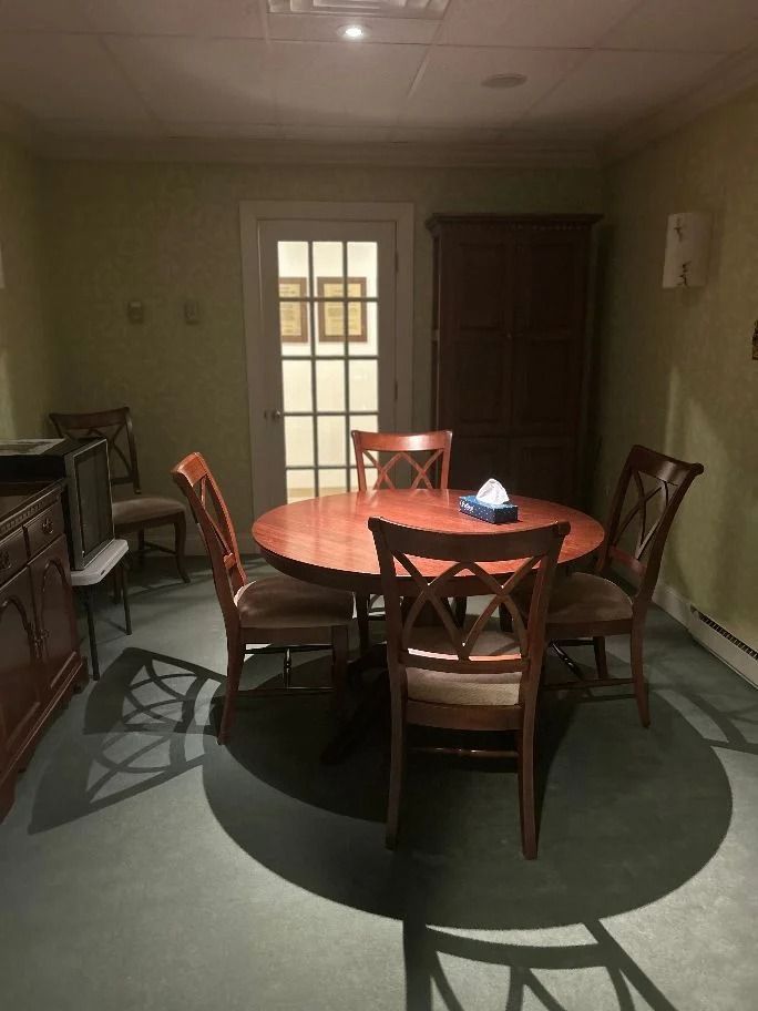 A living room with a couch , chairs , and a coffin.