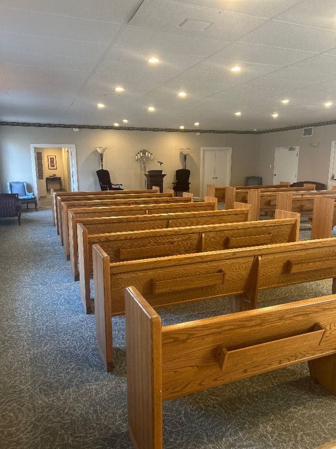 An artist 's impression of a hotel lobby with a couch , chairs , and plants.