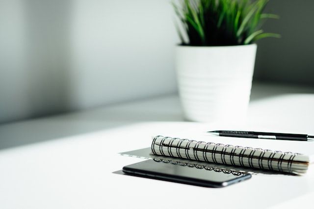 Notebook, phone, and workspace representing compassionate cremation services in Portland ME with supportive funeral planning and memorial care assistance.