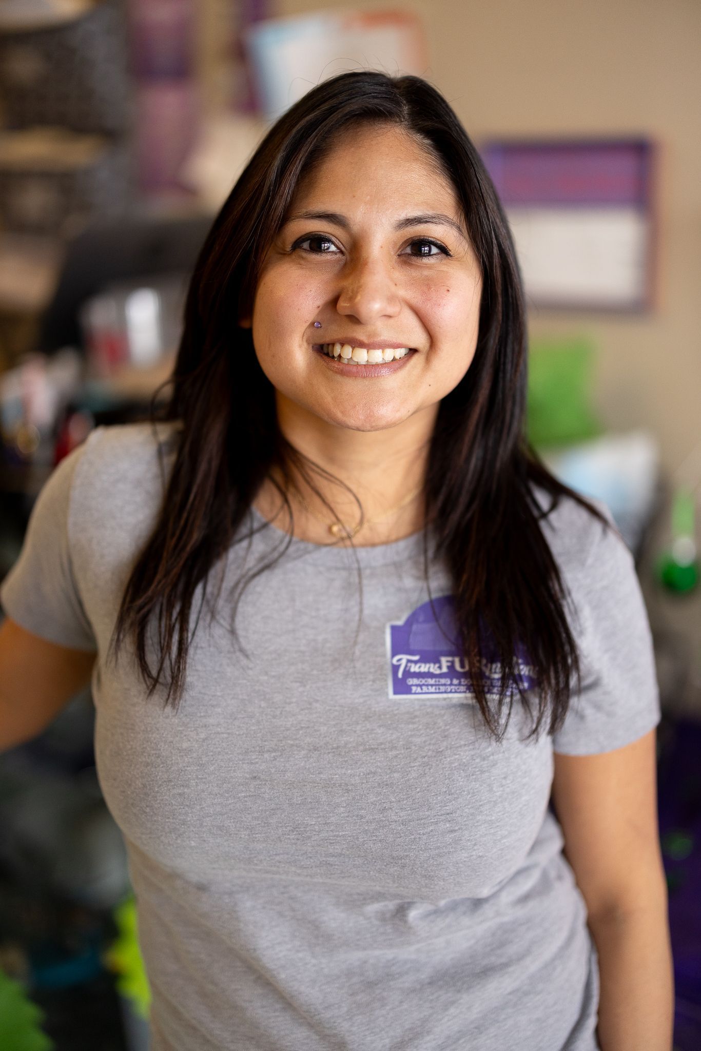 A woman is leaning against a wall and smiling.