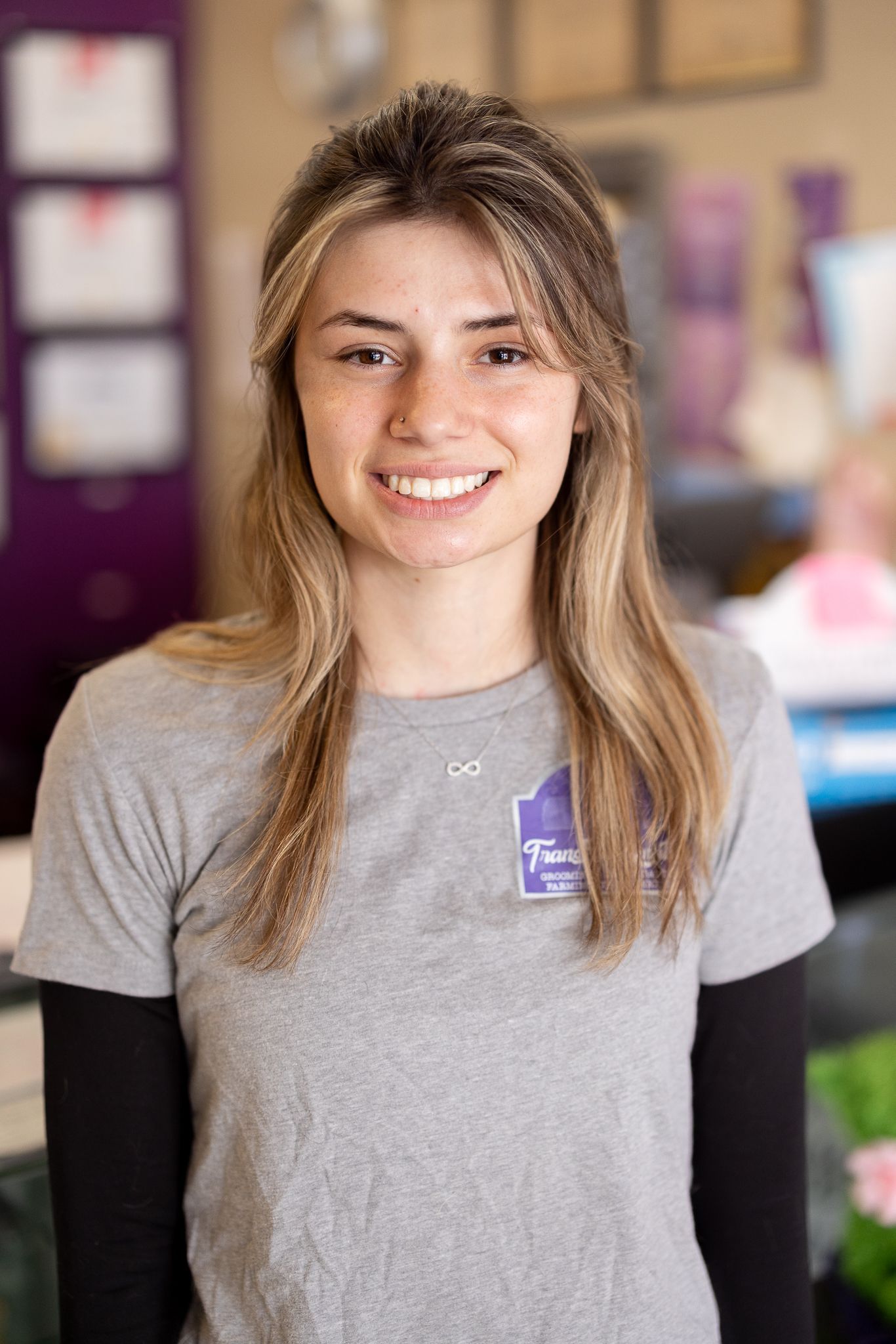 A young woman is wearing a roverfest t-shirt and smiling.