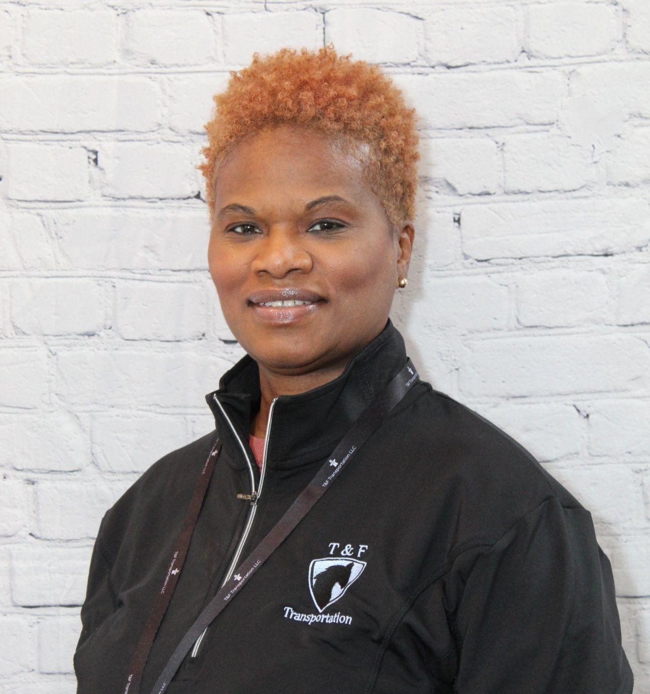 A woman wearing a black jacket with the word transportation on it