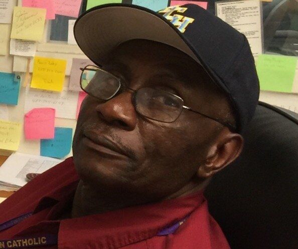 A man wearing a hat with the letter h on it