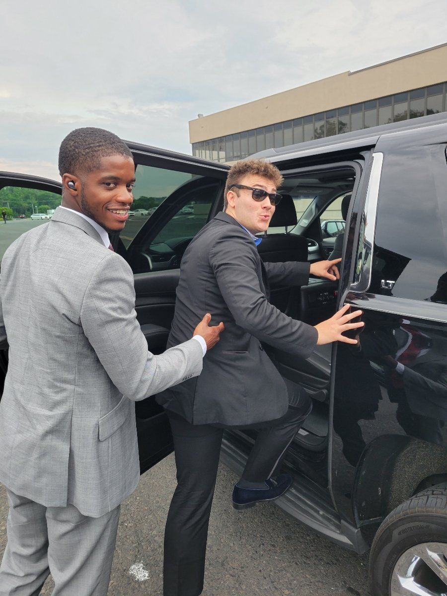 Two men in suits are getting out of a car.