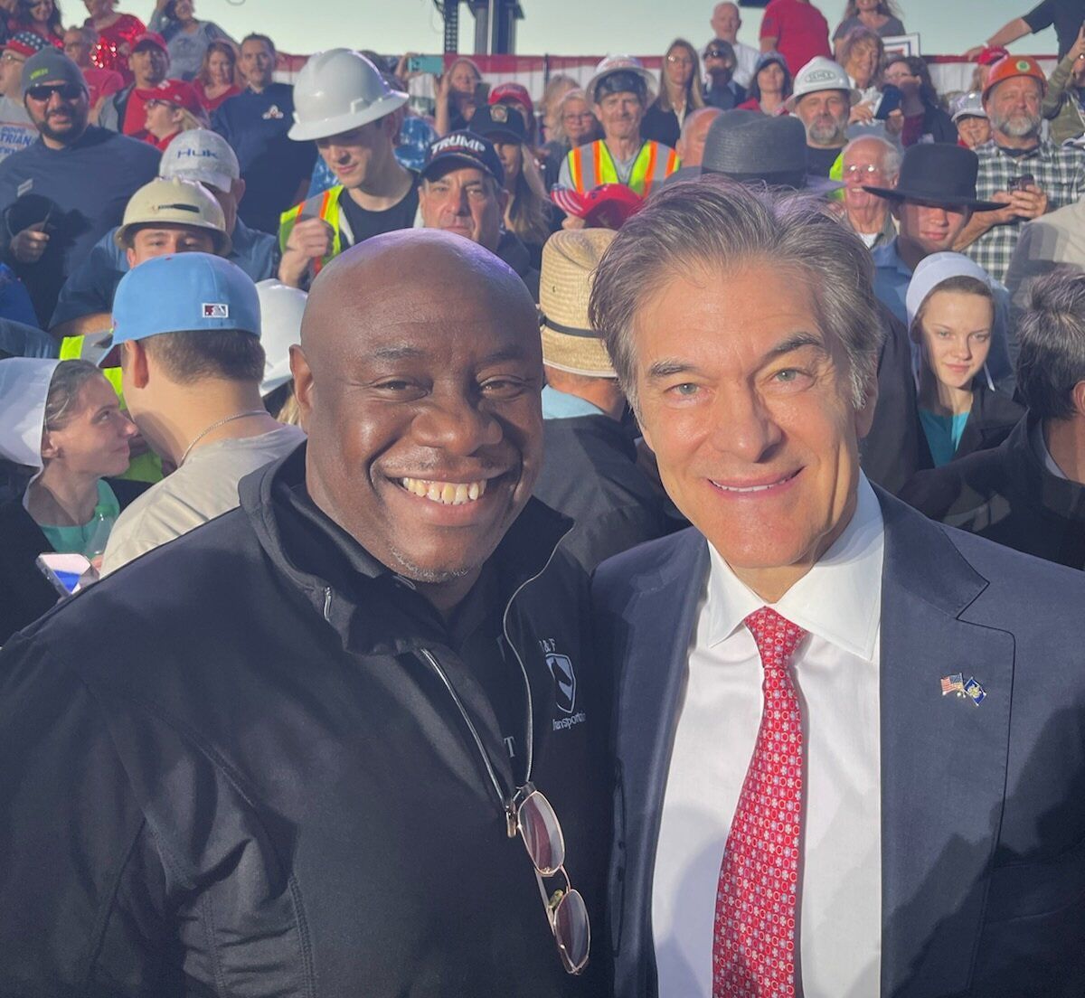 Two men are posing for a picture in front of a crowd
