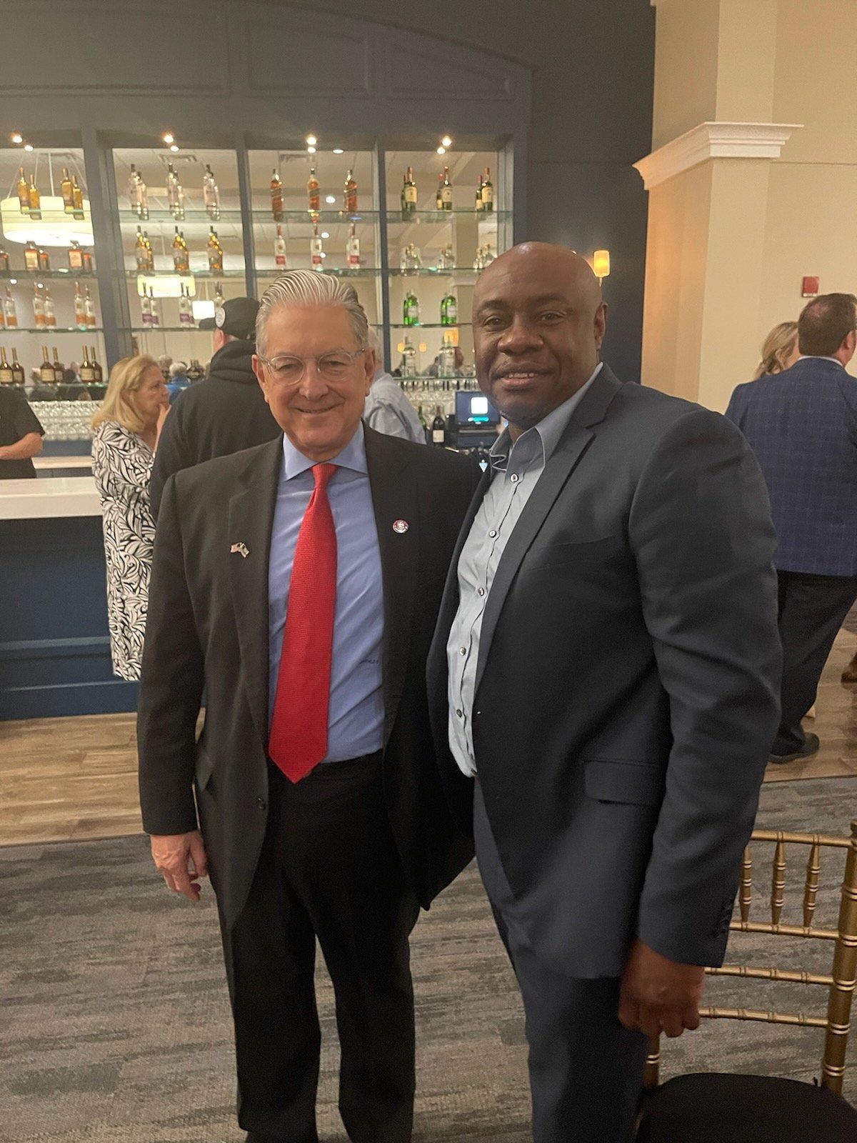Two men in suits and ties are posing for a picture