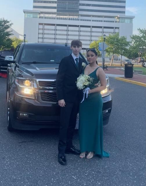 A man and a woman standing in front of a car
