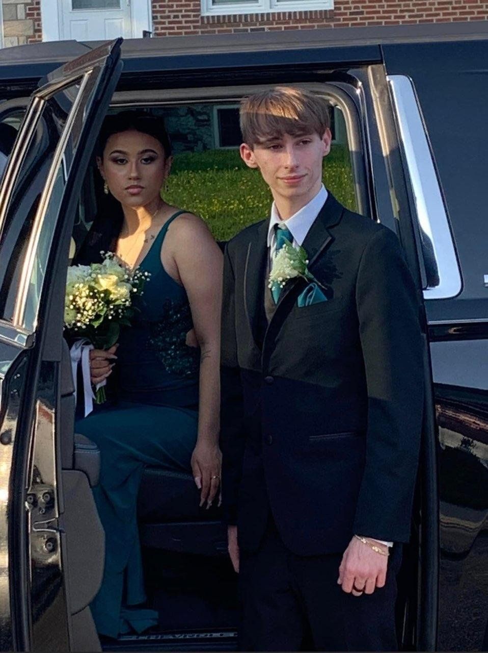 A man and a woman are getting out of a limousine.