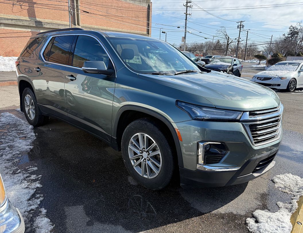 A dark green Chevrolet Traverse SUV parked in a lot with patches of snow on the ground on a sunny day. | Big n' Littles Auto Body