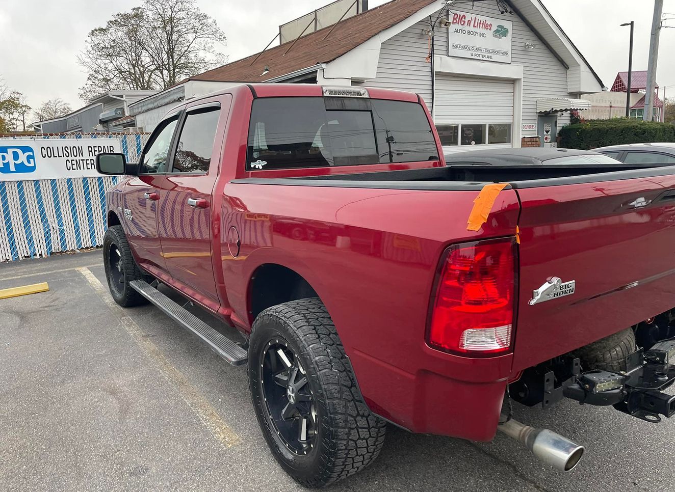Red pickup truck parked outdoors. Truck bed, black wheels, and exhaust visible. | Big n' Littles Auto Body