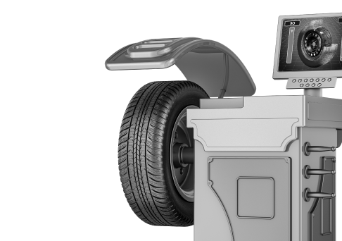 Tire balanced on a machine, with a monitor displaying readings, in a shop setting. | Big n' Littles Auto Body