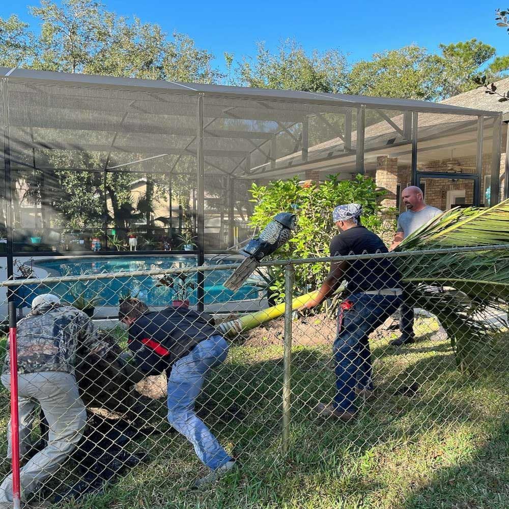 A group of men are working on a chain link fence.
