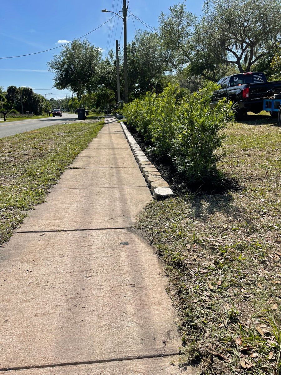 A sidewalk leading to a street with a truck parked on the side of the road.