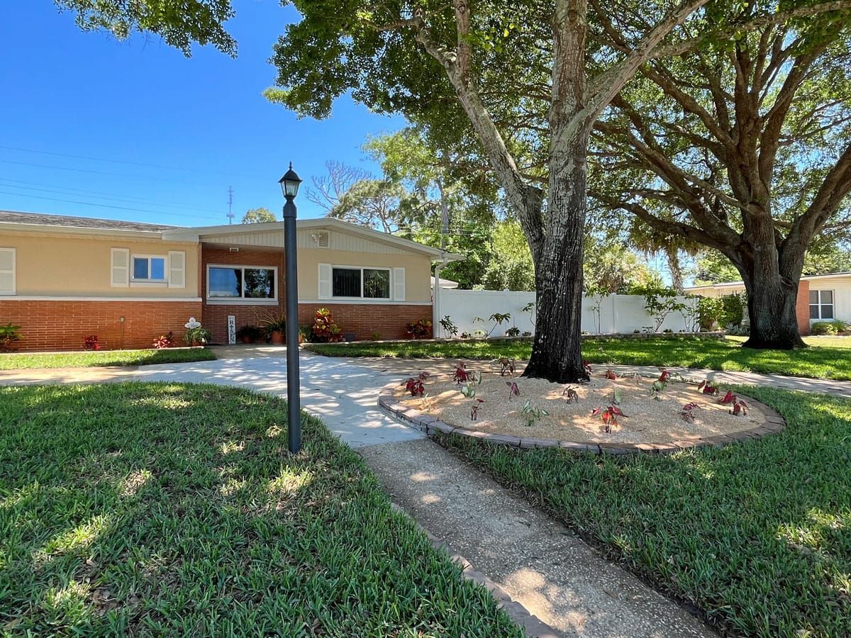 A house with a lot of grass and trees in front of it