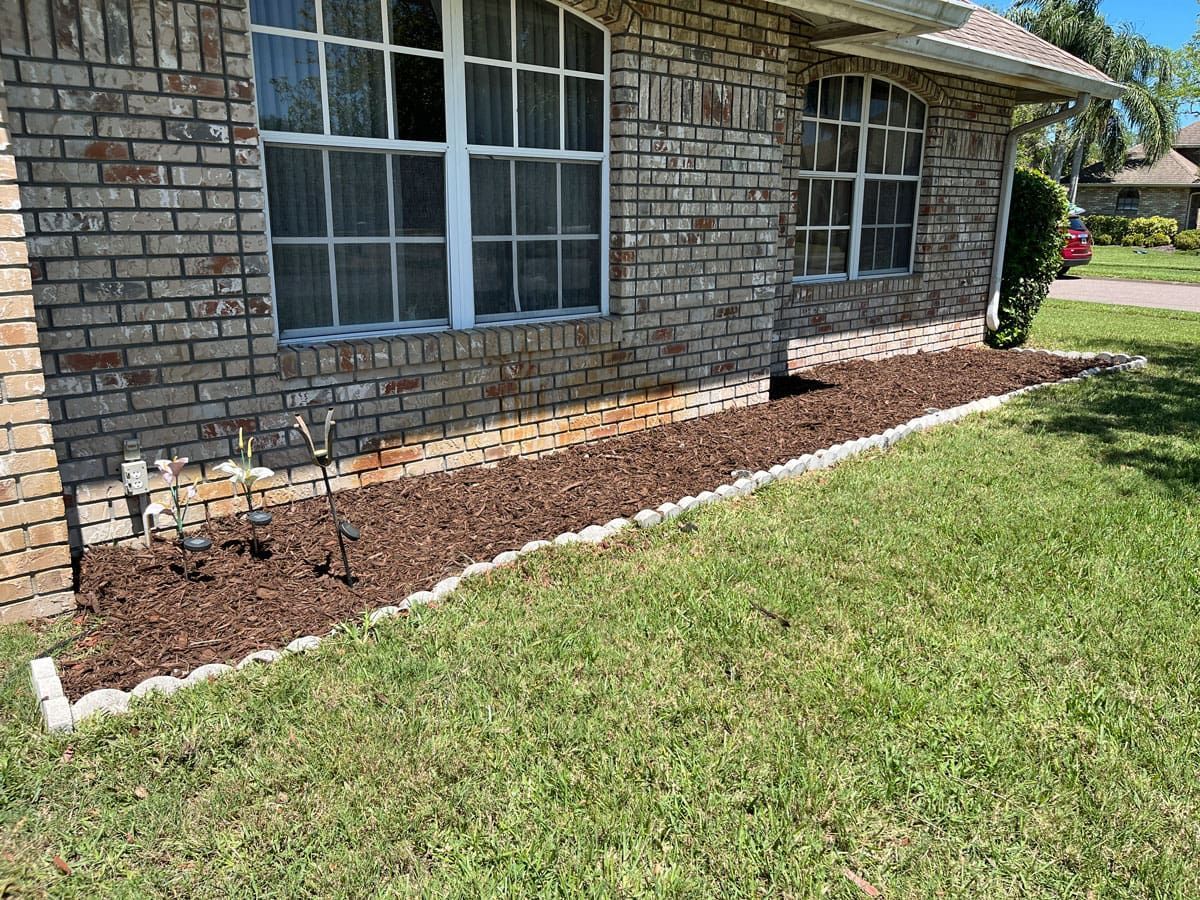 A brick house with a lush green lawn in front of it.