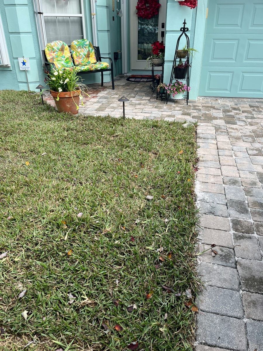 There is a bench in the grass in front of a house.