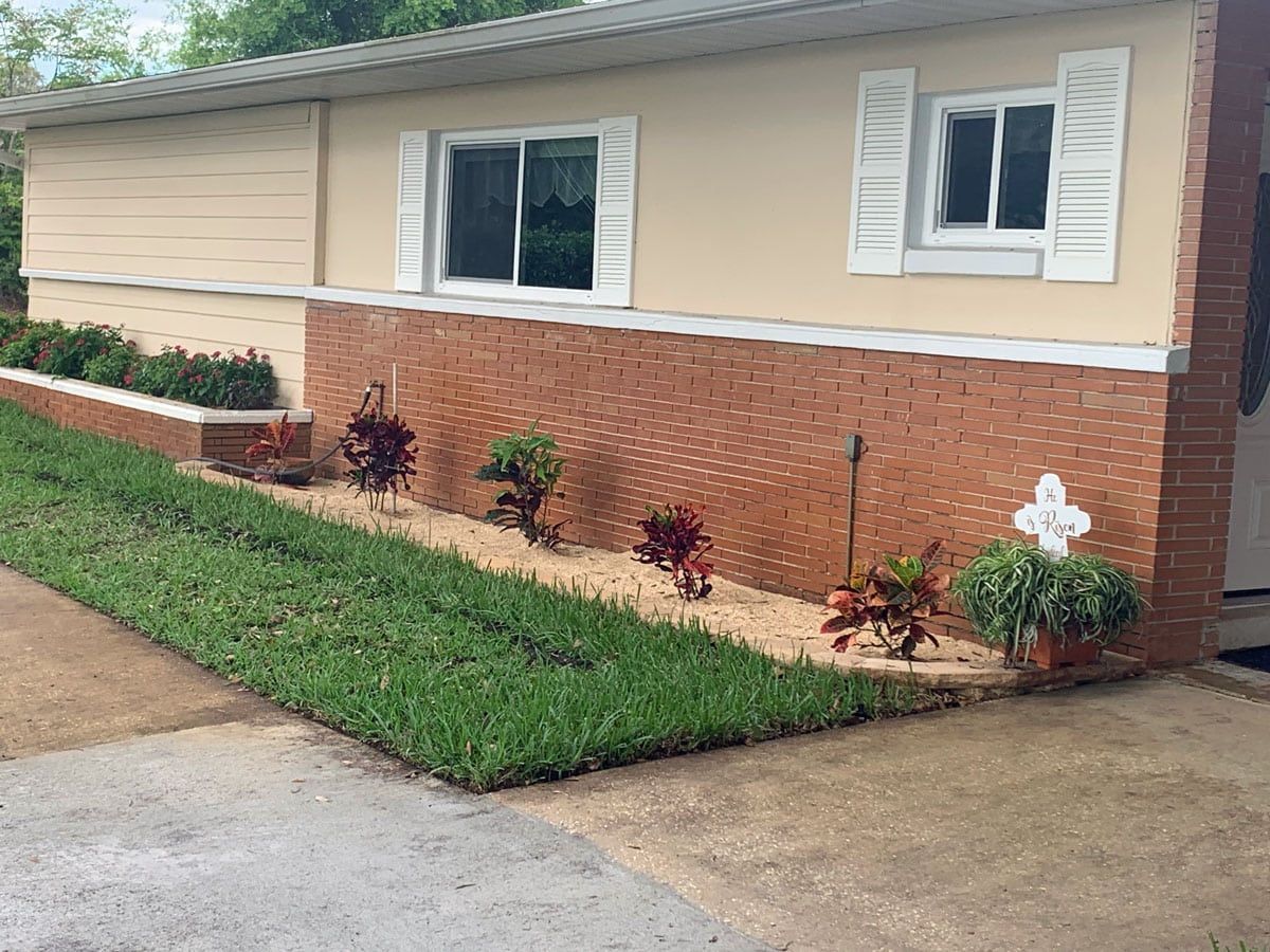 A mobile home with a lush green lawn in front of it.