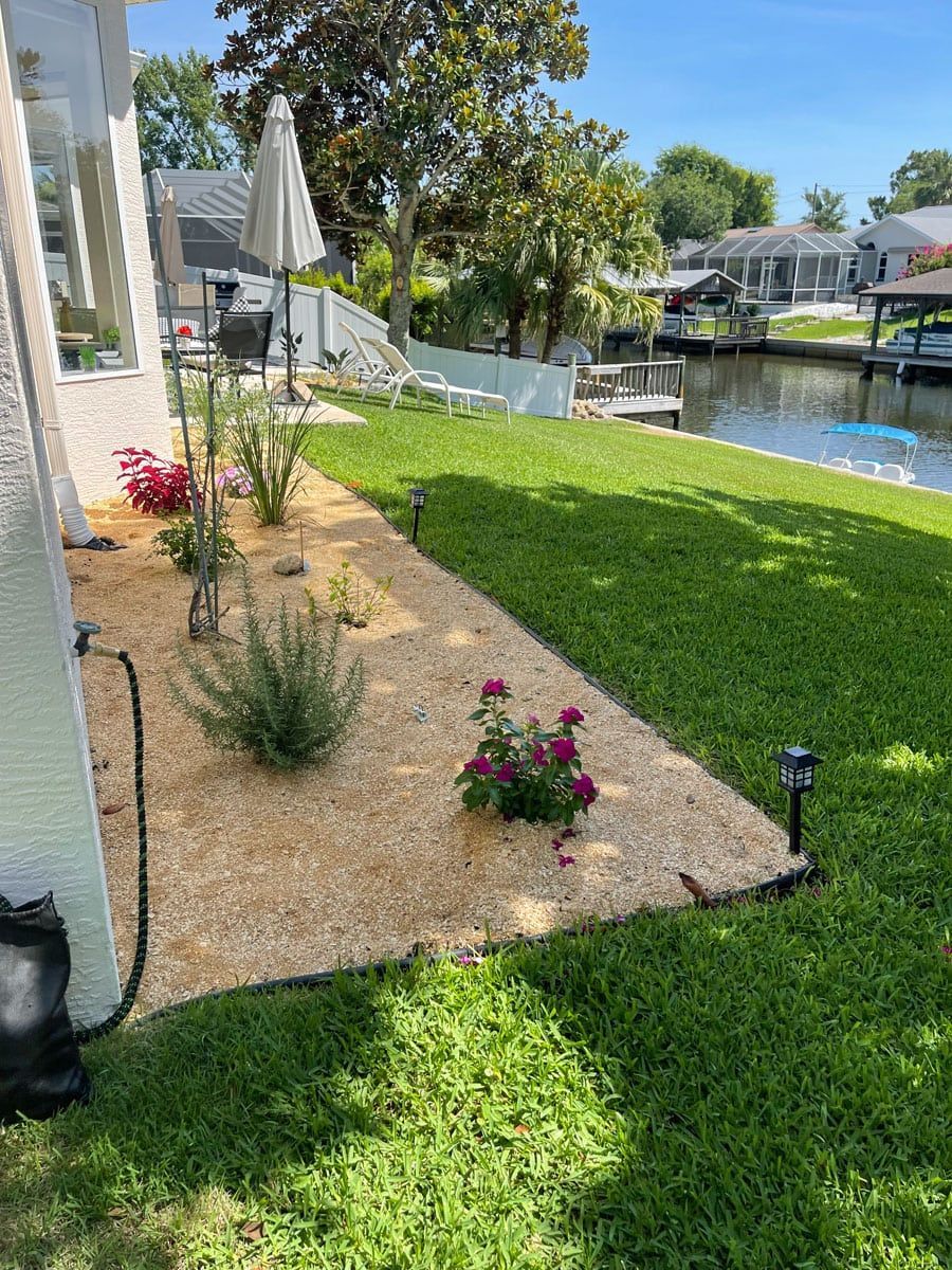 A lush green lawn next to a body of water with a boat in the background.