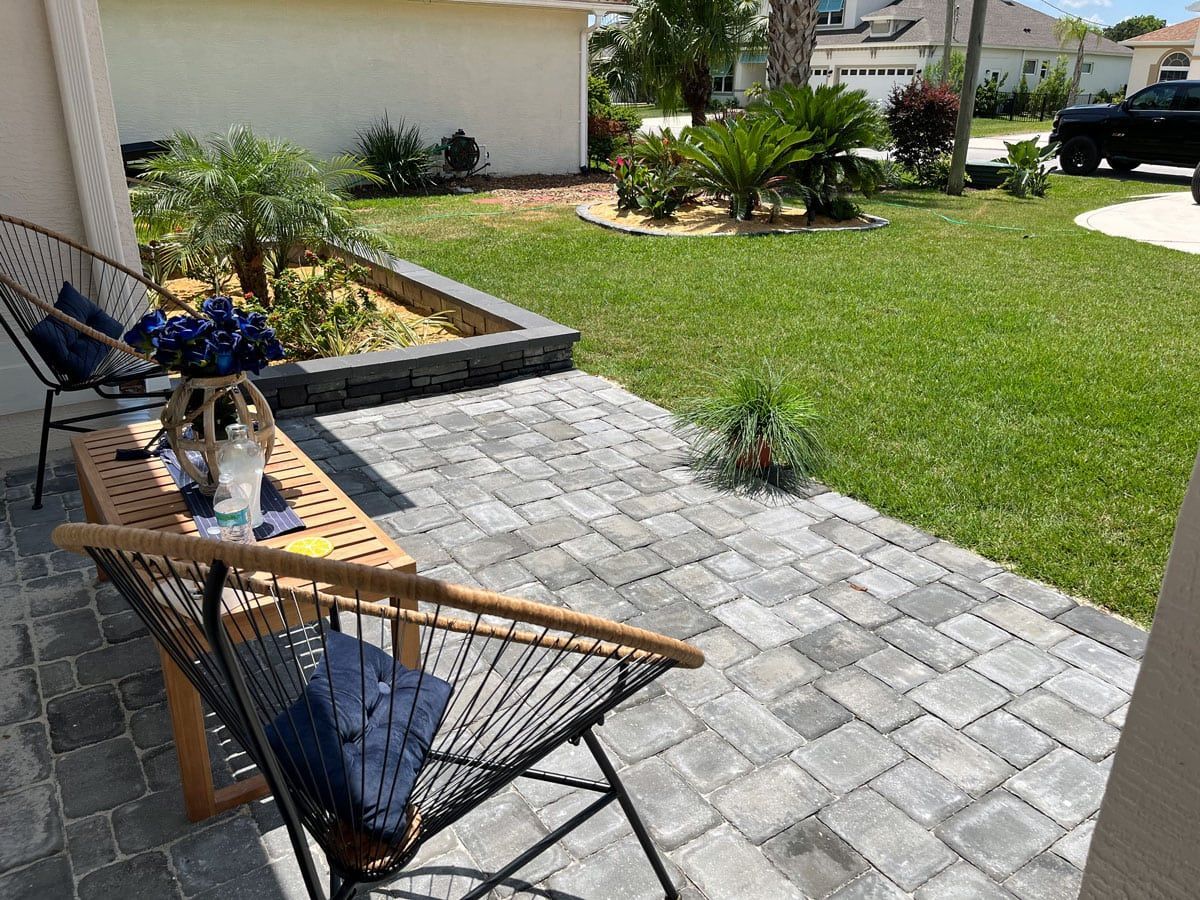 A patio with a table and chairs in front of a house.