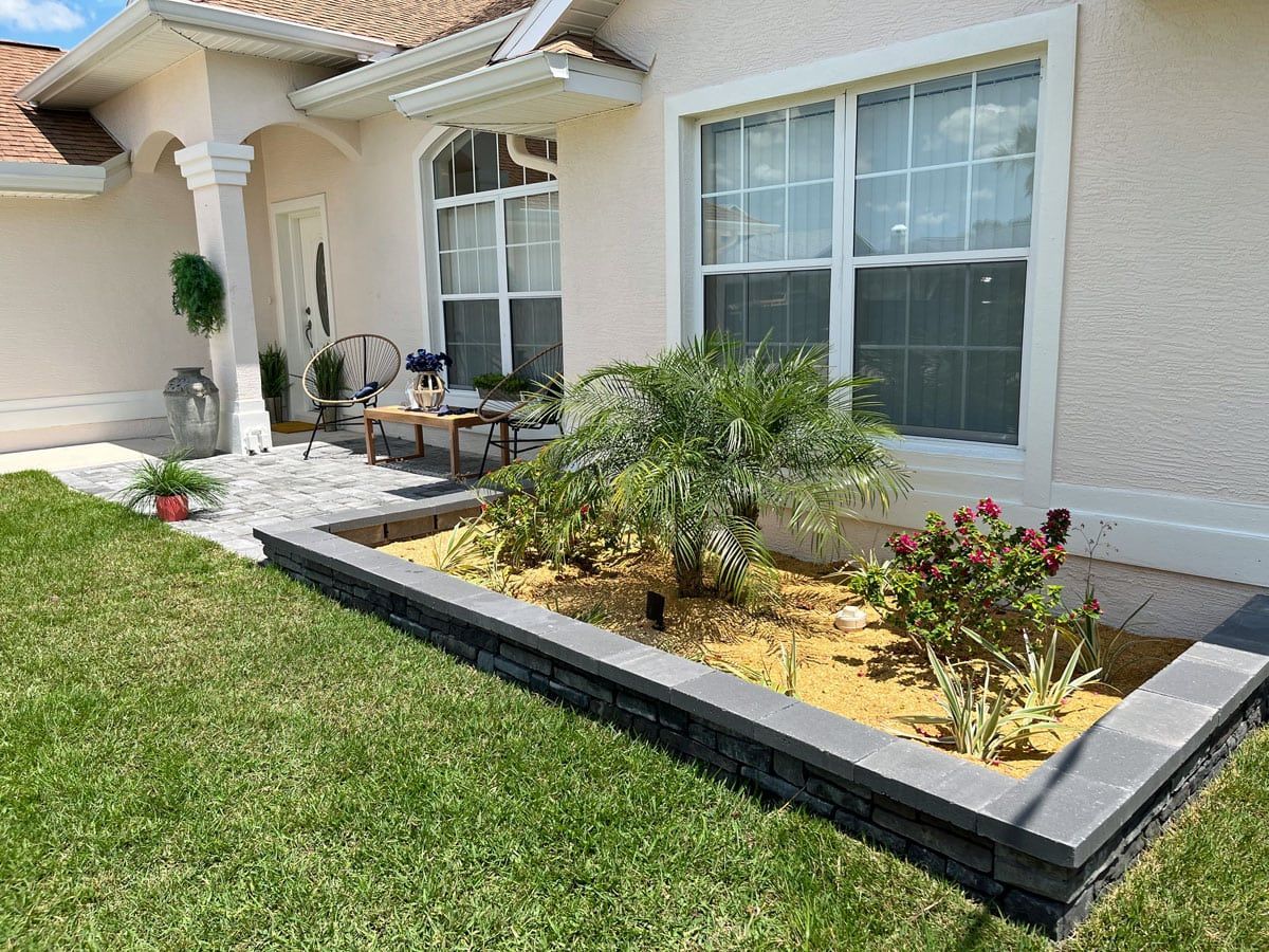 A white house with a garden in front of it.
