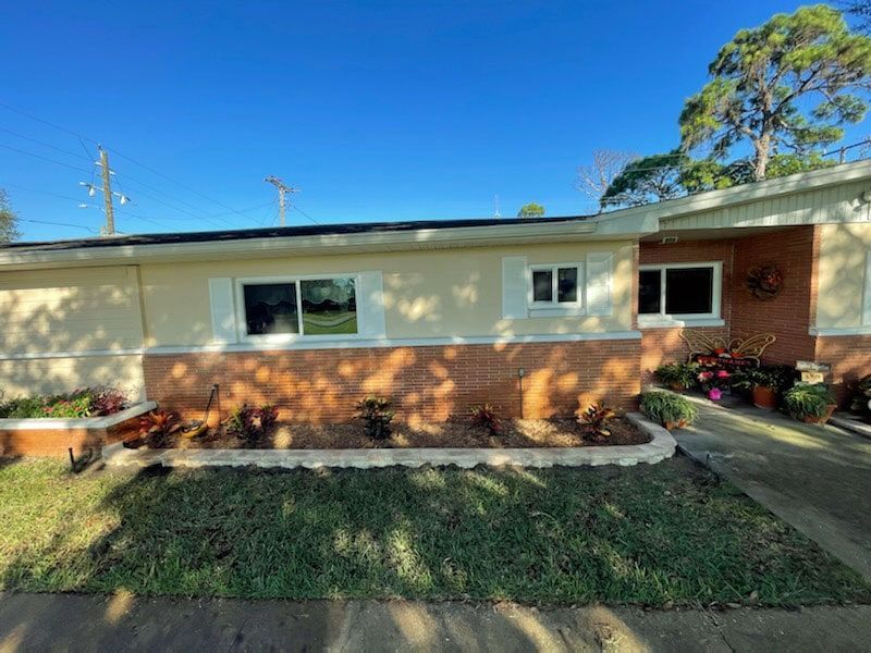 A house with a lot of plants in front of it.