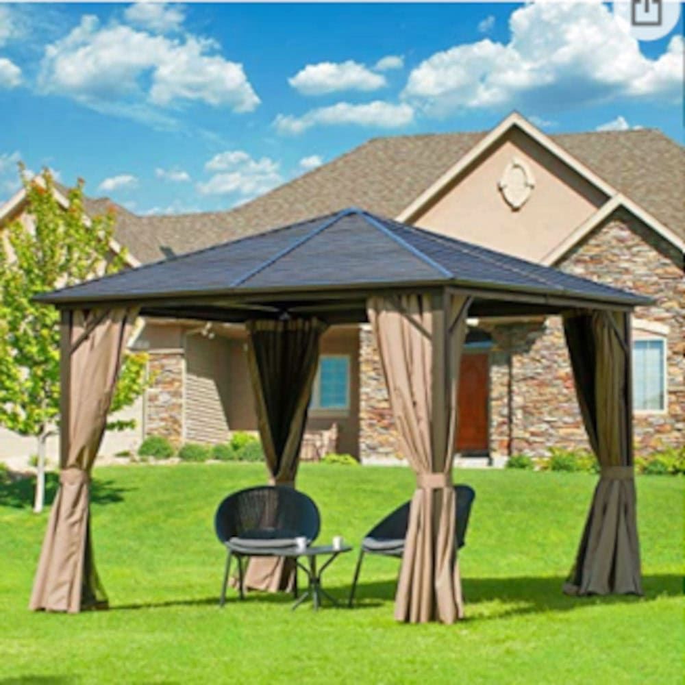 A gazebo with chairs and a table in front of a house