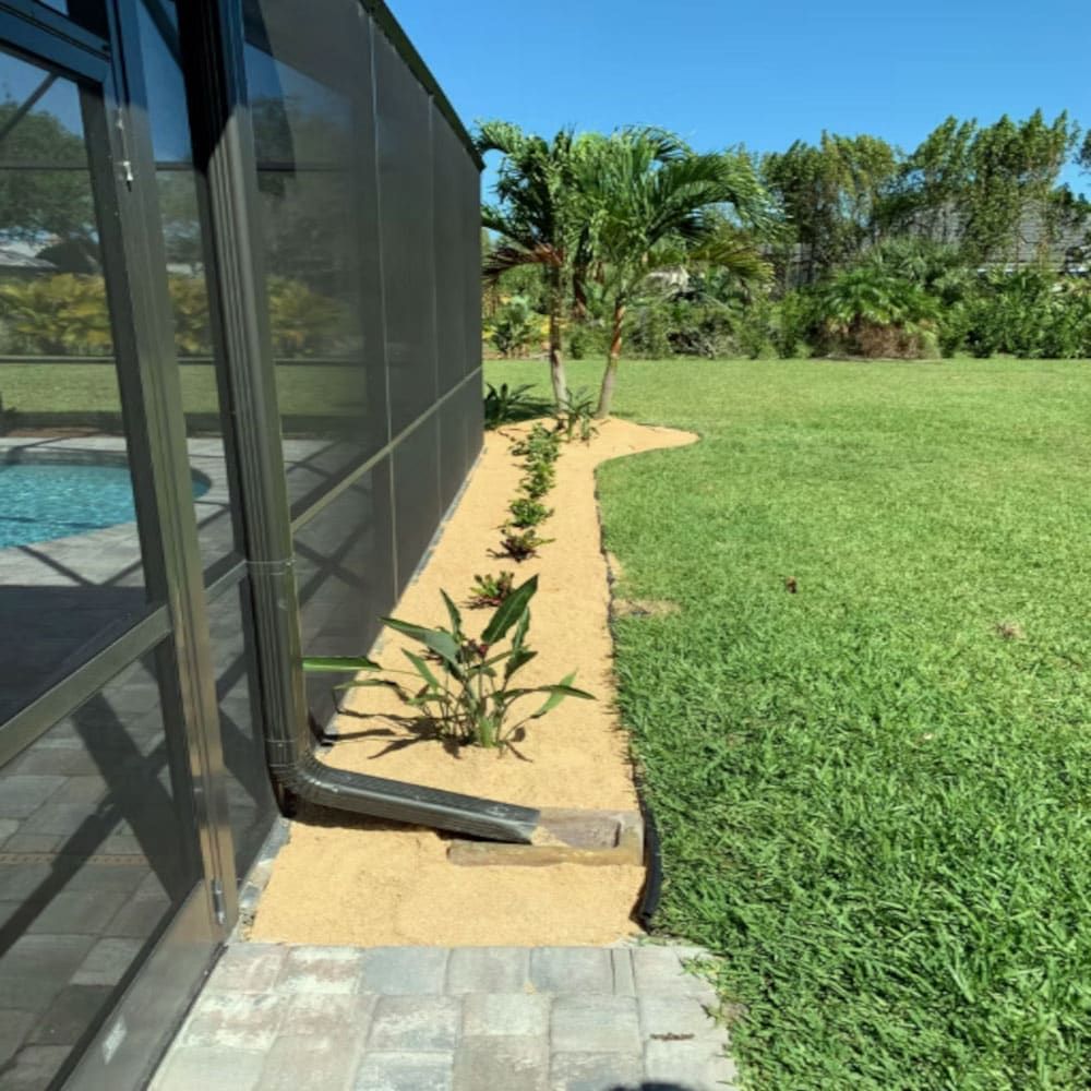 A screened in pool area with a drain pipe in the grass
