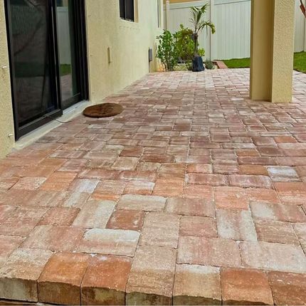 A brick patio in front of a house.