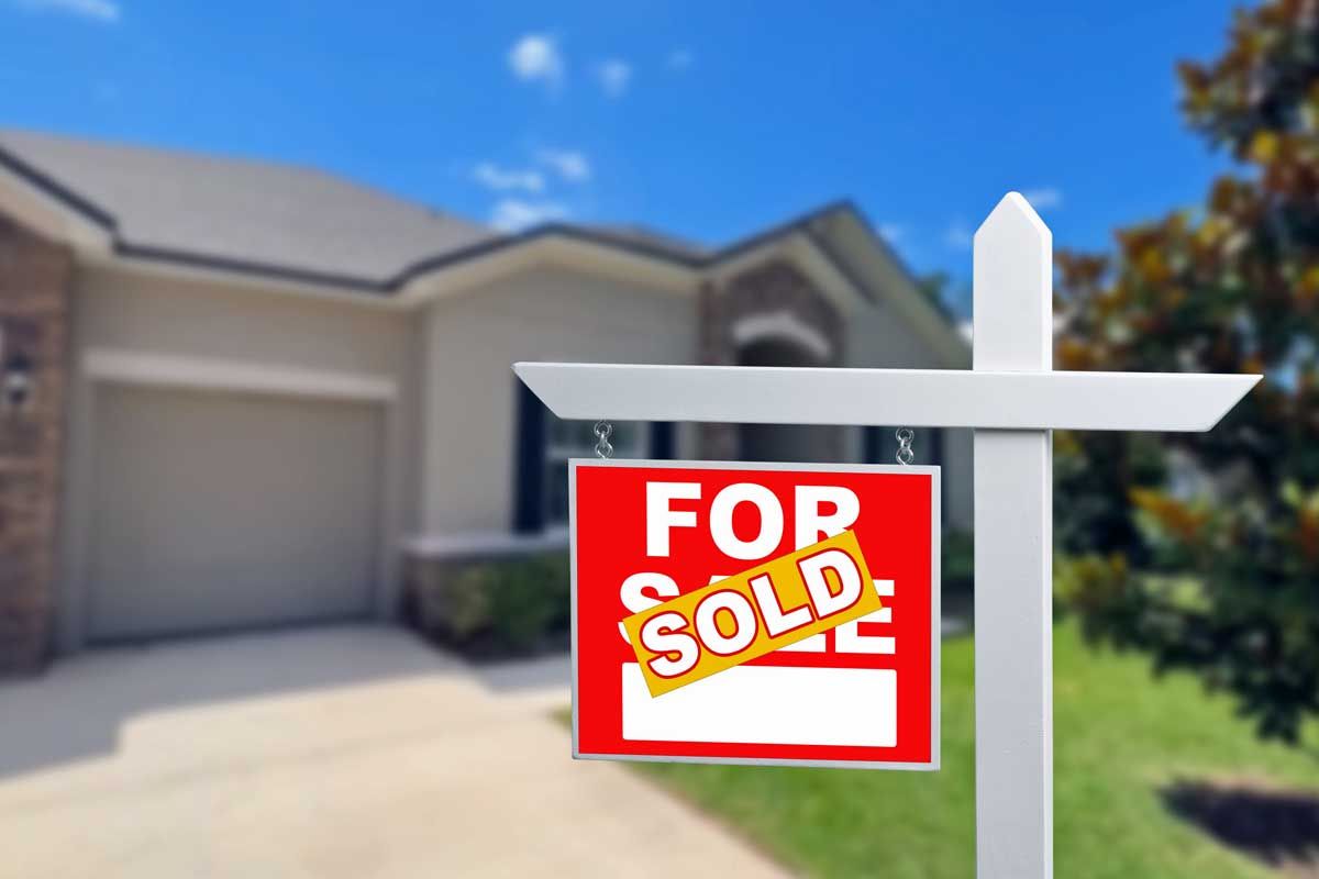 A for sale sign in front of a house