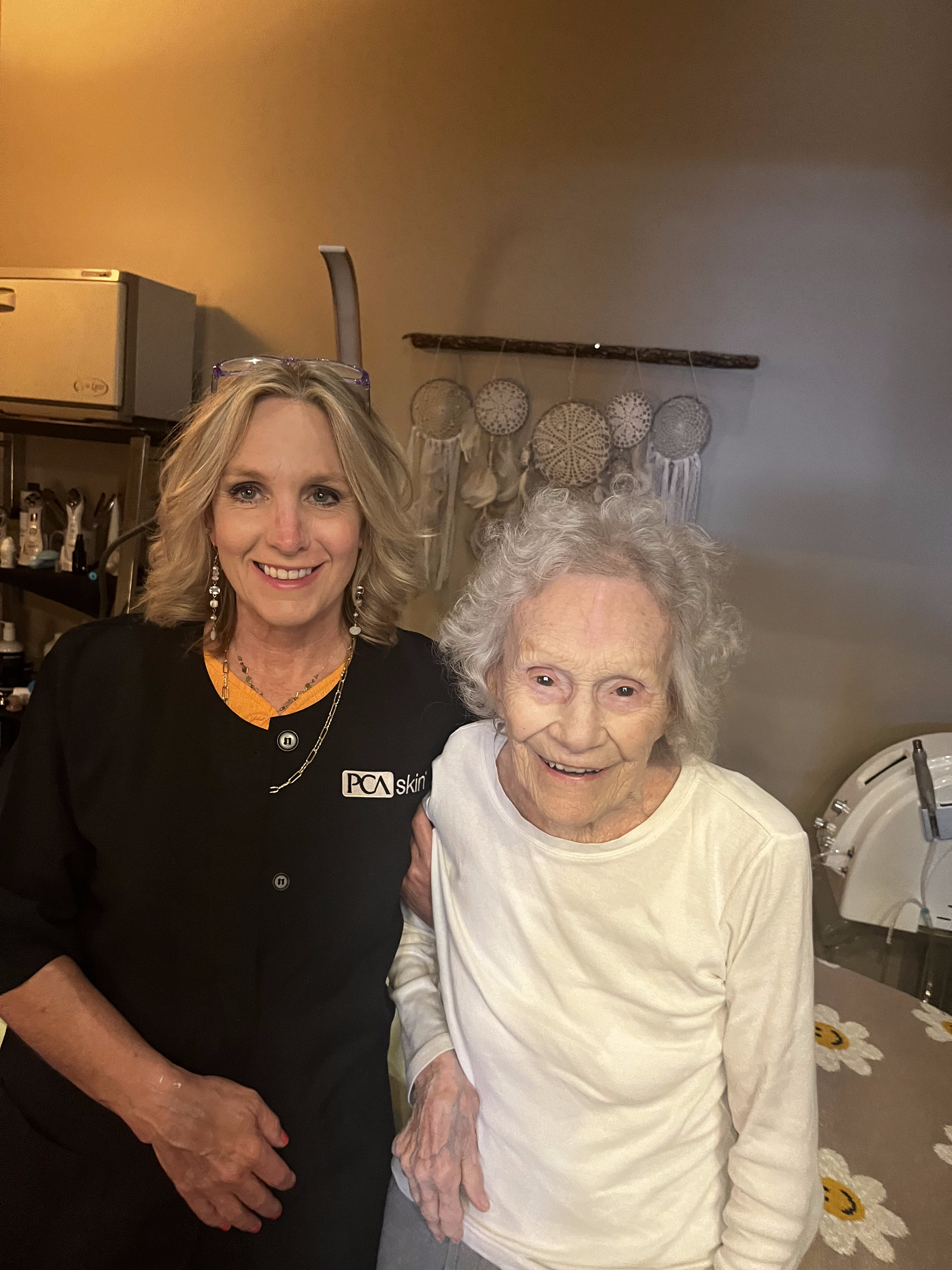 A woman is standing next to an older woman in a room.