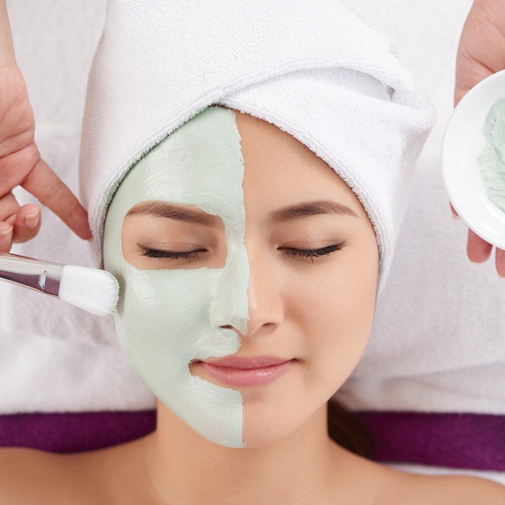 Beautician Applying Clay Face Mask on Face of Young Woman — Schererville, IN — Jill's Skin Care