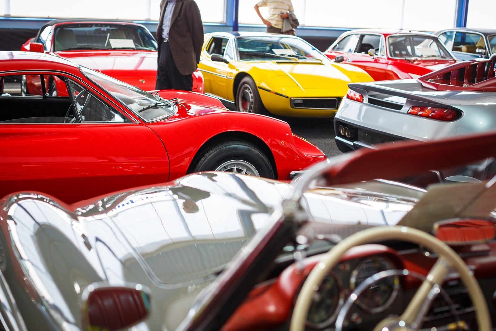 A man is standing in front of a row of cars