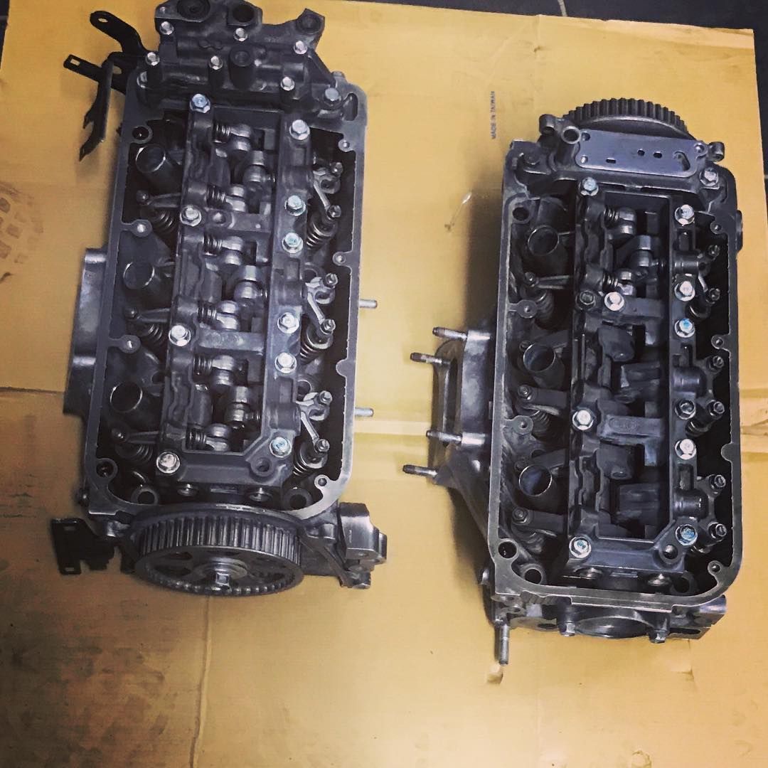 Two engine heads are sitting on a piece of cardboard