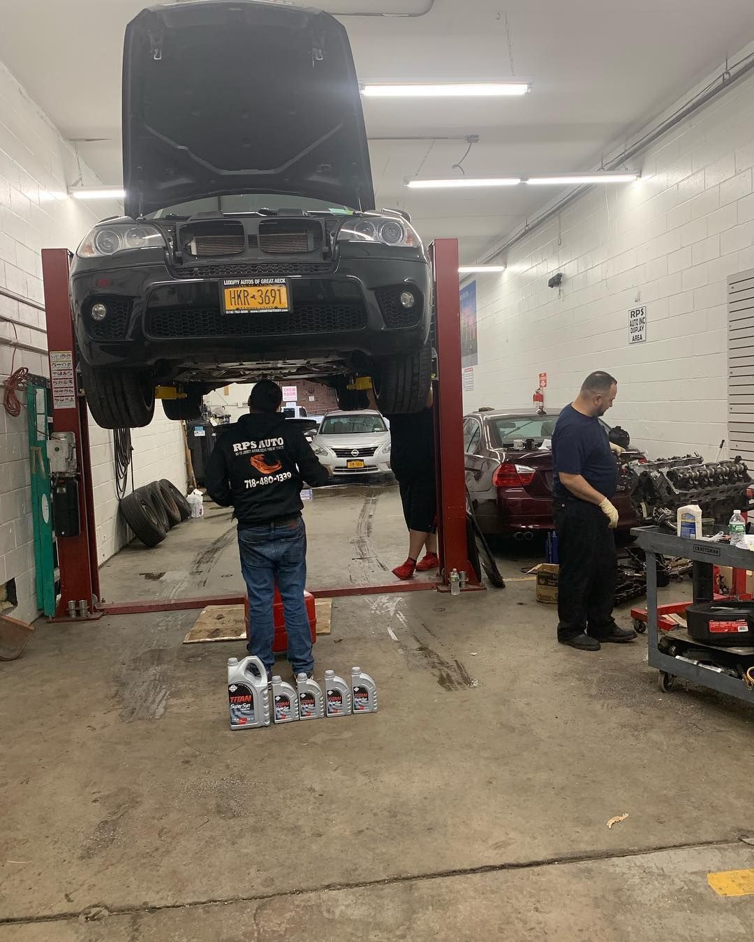 A car is sitting on a lift in a garage.