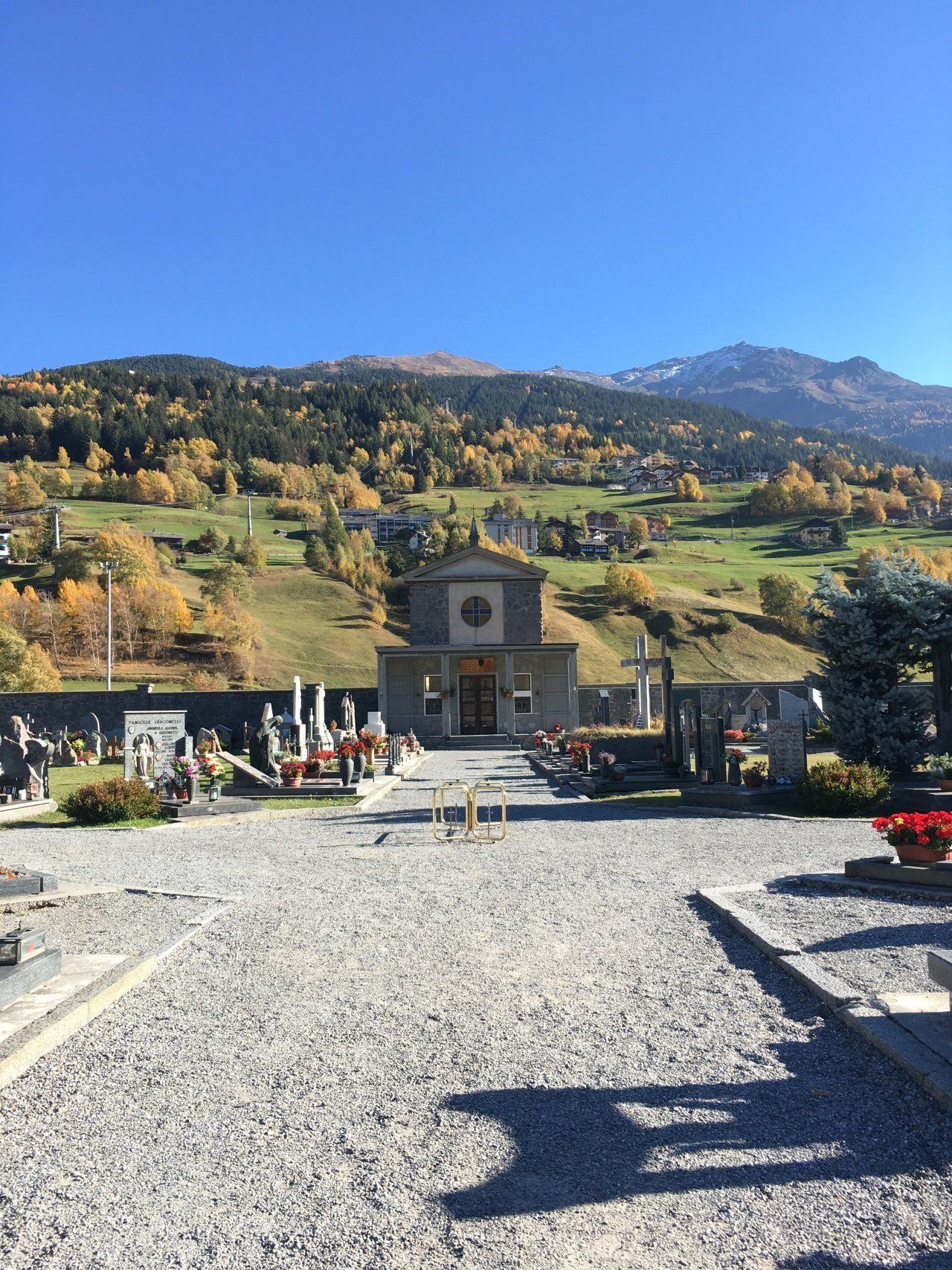 Un cimitero con una chiesa sullo sfondo e montagne sullo sfondo