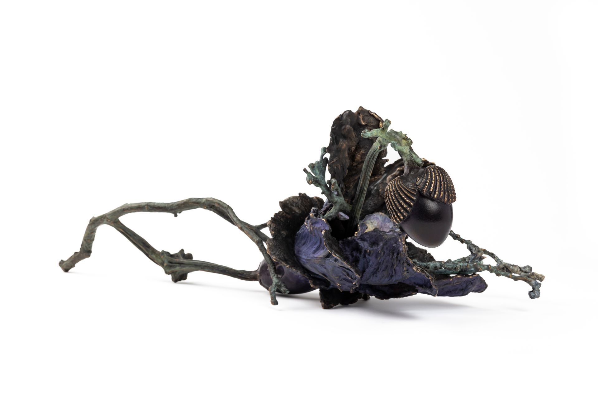 Sculpture en bronze d'une fleur sombre avec des baies et des branches, sur fond blanc.