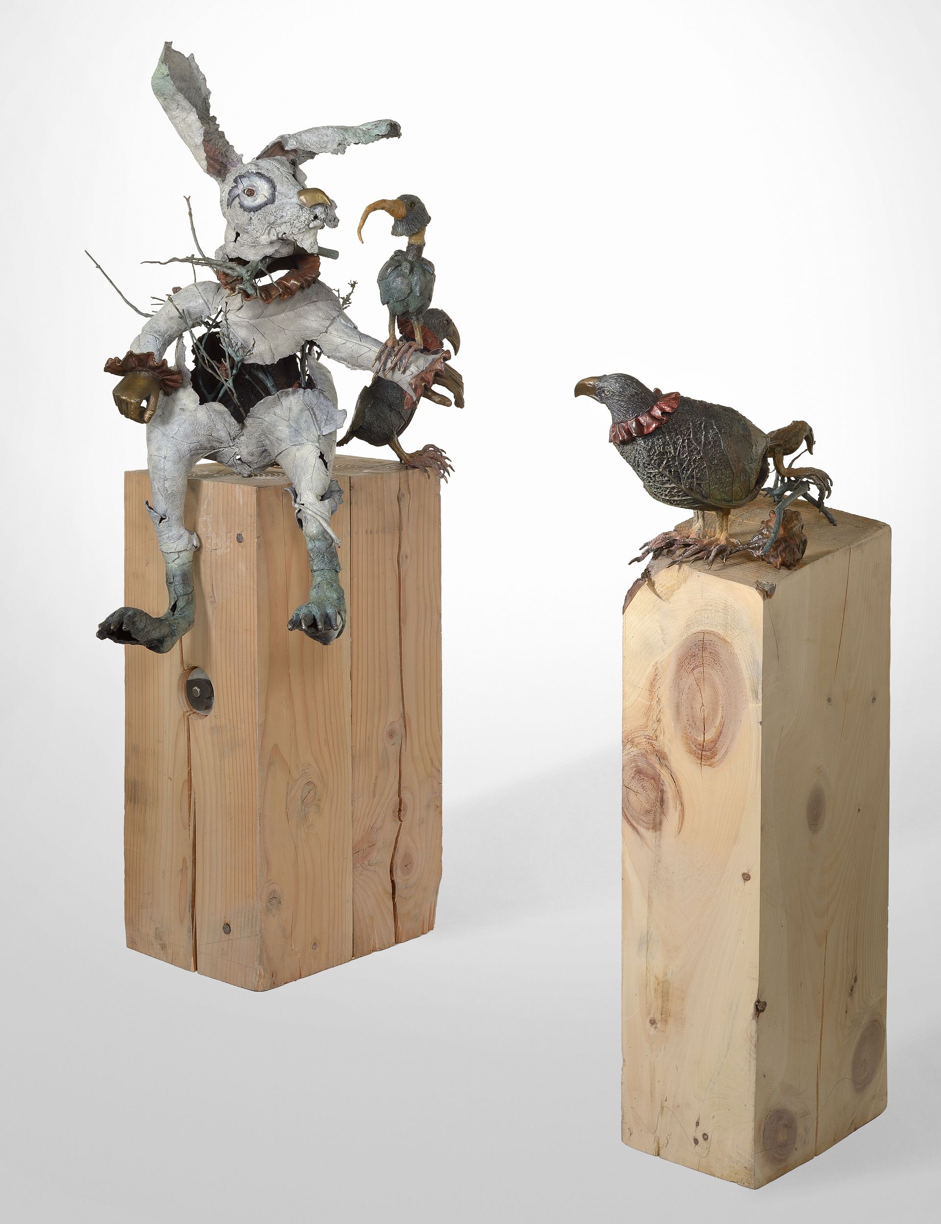 Sculptures d'un lapin et d'un oiseau sur des socles en bois ; le lapin a des amis oiseaux.