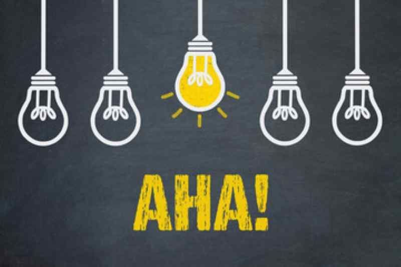 A chalkboard with light bulbs and the word aha written on it