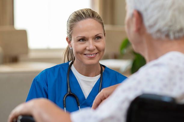 A nurse is talking to an elderly man in a wheelchair - New City, NY - A & T Certified