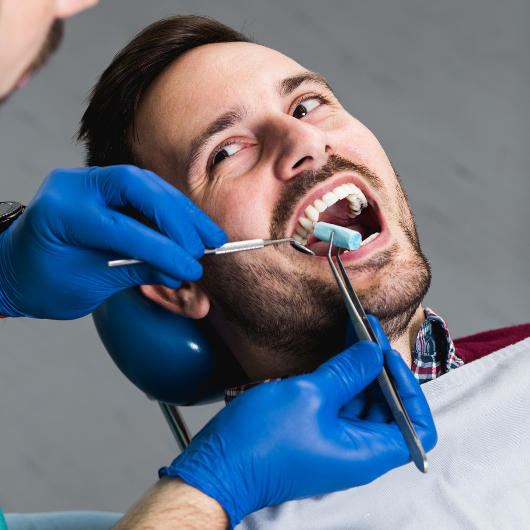 Image of patient smiling at dentist with dental instruments